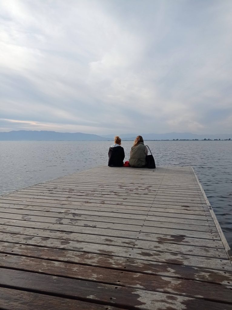 Dos mujeres maduras disfrutando de un atardecer en un destino tranquilo. Un momento de paz y conexión con lka naturaleza, reflejando la libertad de viajr a su propio ritmo
